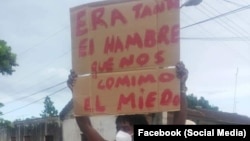 Juan Enrique Pérez Sánchez sostiene un cartel que reza: "Era tanta el hambre que nos comimos el miedo", en la manifestación del 11 de julio de 2021, en Nueva Paz, Mayabeque.