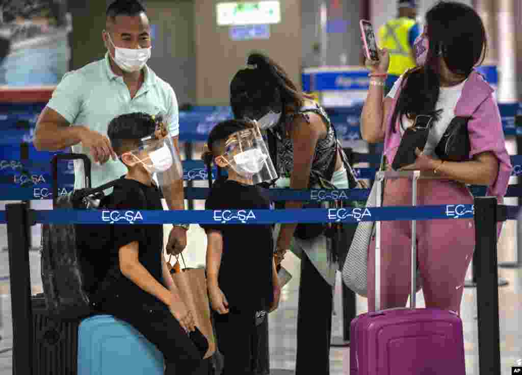 Una familia en el Aeropuerto Internacional José Martí de La Habana, con máscaras de protección contra el coronavirus, tras la reapertura de la terminal aérea. (AP Photo/Ramon Espinosa)