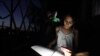Una niña hace la tarea con la luz de su celular en medio de un apagón en La Habana, Cuba. (REUTERS/Alexandre Meneghini/Archivo)
