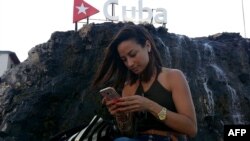 Una cubana chequea su teléfono móvil en una calle de La Habana. El vertical se ha convertido en un formato cada vez más popular en diferentes géneros cinematográficos.