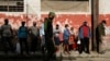 Un agente del MININT controla una cola en un mercado de La Habana. REUTERS/Stringer