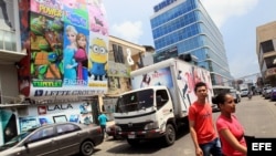 Dos personas cruzan por una calle de la Zona Libre de Colón, adonde concurren tanto agentes comerciales del gobierno como compradores de insumos para el sector privado cubano.