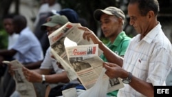Varios hombres leen el diario oficial Granma en La Habana (Cuba).