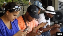 Jóvenes navegan por internet desde sus dispositivos móviles en una de las zonas habilitadas con Wi-fi en La Habana (julio, 2015).