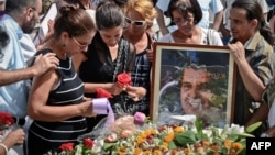 Ofelia Acevedo (izq.), viuda del líder opositor Oswaldo Payá, y su hija Rosa María Payá (segunda izq.) asisten a su funeral, el 24 de julio de 2012 en el cementerio Cristóbal Colón en La Habana.