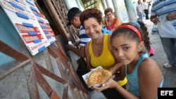 Varias personas compran pizzas en una cafetería gestionada por trabajadores por cuenta propia en La Habana.