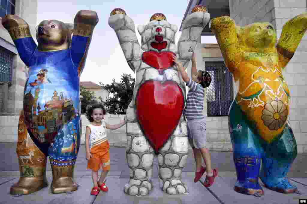 Dos niños israelíes juegan junto al "Oso Amigo" israelí y al "Oso amigo" iraní en la exhibición de los 'United Buddy Bears 2007' ("Amigos Osos Unidos") situada cerca del Ayuntamiento de Jerusalén, en Israel, en el 2007.